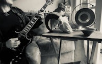 a black and white photo of a man playing an electric guitar